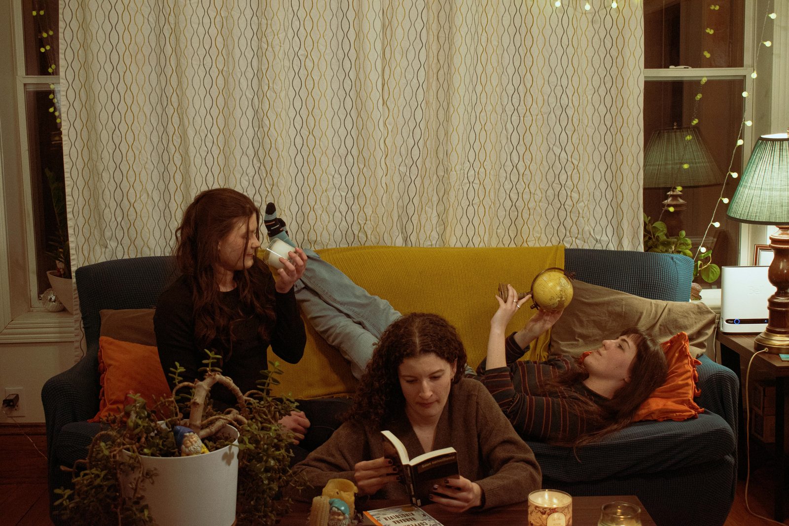 Three friends relaxing together on a sofa in a cosy living room